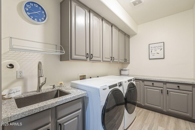 4915 N Greentree Dr, Litchfield Park, AZ 85340 - laundry area featuring cabinets, washing machine and dryer, sink, and light wood-type flooring