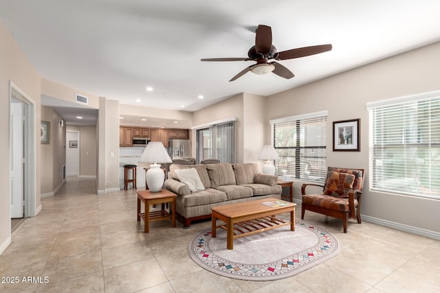 tiled living room featuring plenty of natural light and ceiling fan