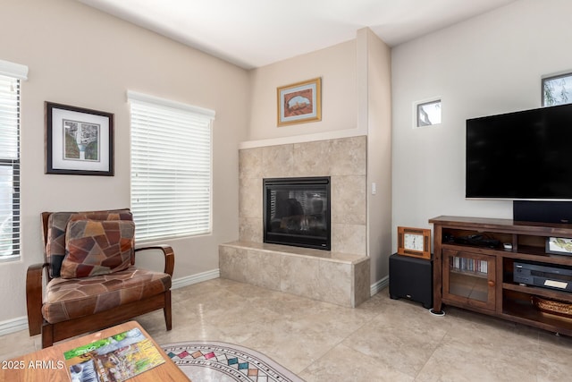 living room with a tiled fireplace and light tile patterned flooring