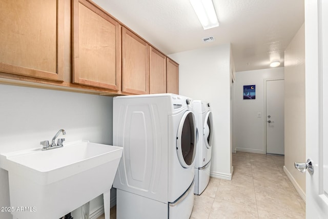 clothes washing area featuring cabinets, washing machine and dryer, sink, and light tile patterned floors