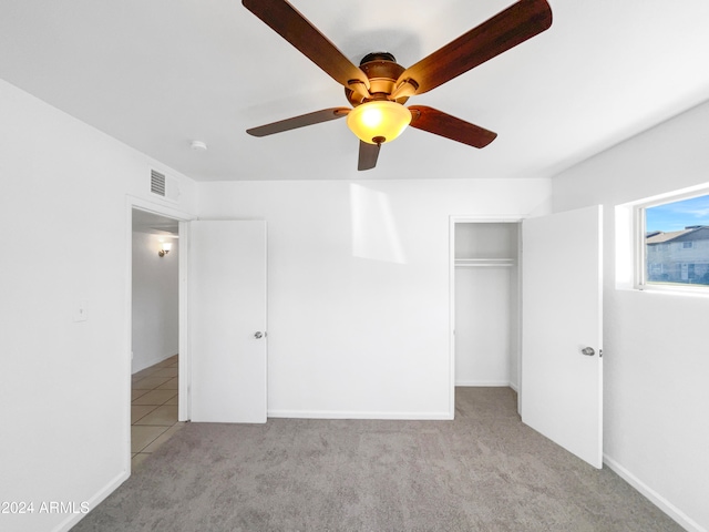 unfurnished bedroom with light carpet, a closet, and ceiling fan