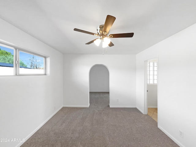 carpeted empty room with a healthy amount of sunlight and ceiling fan