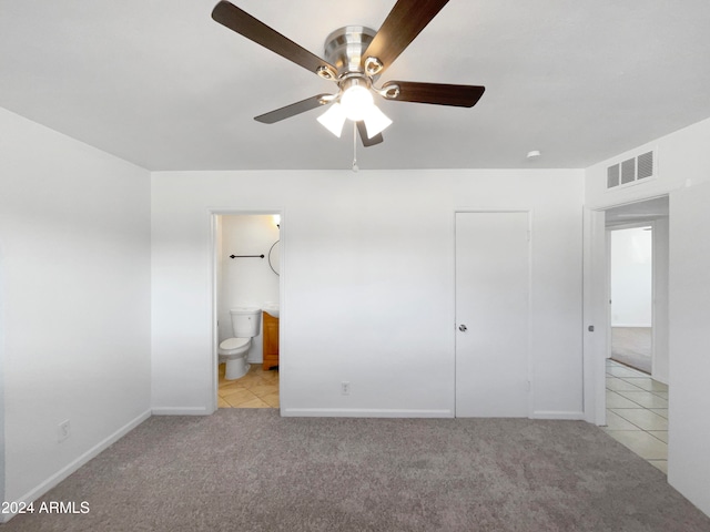 unfurnished bedroom featuring a closet, ceiling fan, connected bathroom, and light carpet