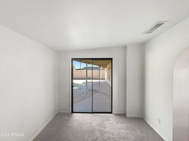 carpeted empty room featuring vaulted ceiling