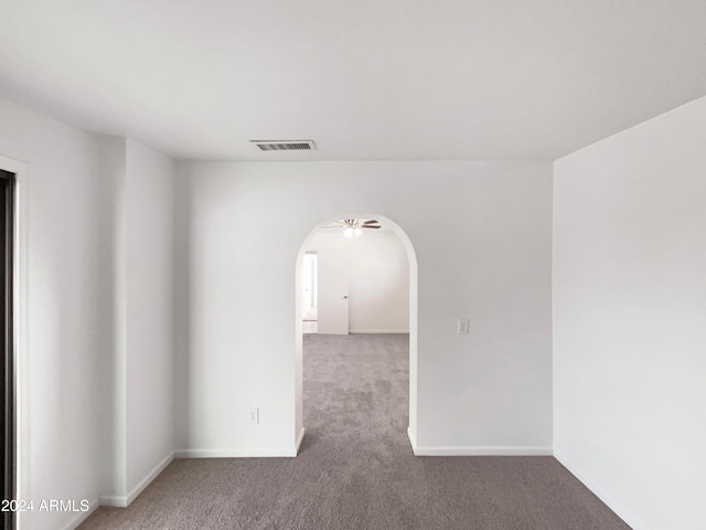 carpeted spare room featuring ceiling fan