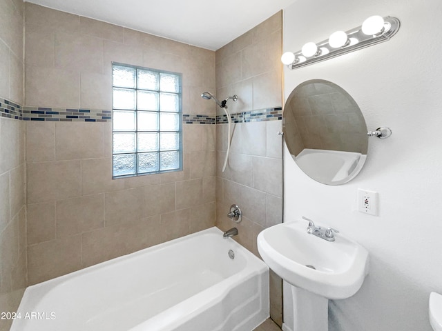 full bathroom with tiled shower / bath, sink, and toilet