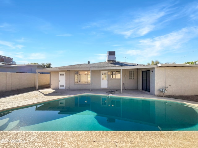 view of pool with cooling unit and a patio