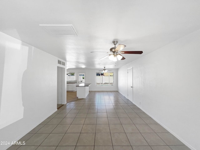 unfurnished living room featuring tile patterned floors and ceiling fan