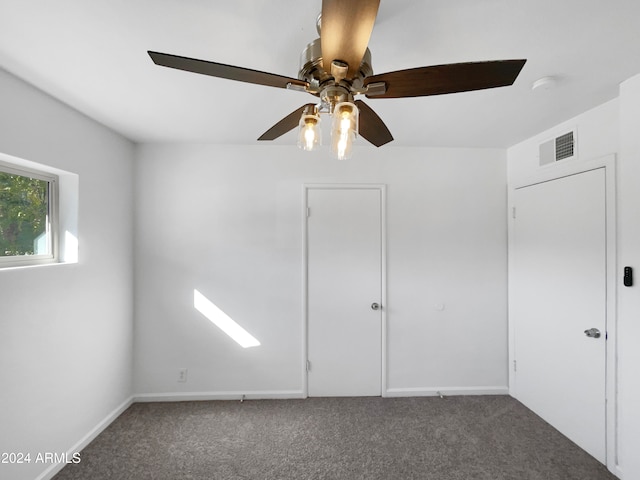 unfurnished bedroom featuring dark colored carpet and ceiling fan