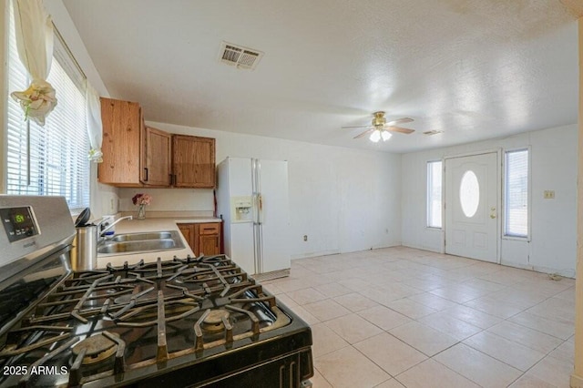 1055 S 4th St, Coolidge, AZ 85128 - kitchen with brown cabinets, visible vents, a sink, white fridge with ice dispenser, and ceiling fan