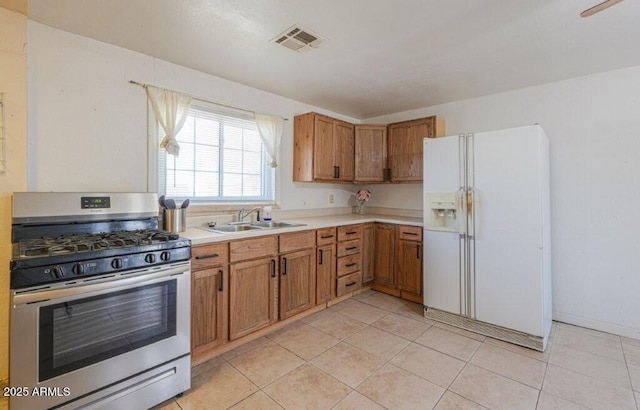 1055 S 4th St, Coolidge, AZ 85128 - kitchen with light countertops, visible vents, a sink, stainless steel gas range, and white refrigerator with ice dispenser