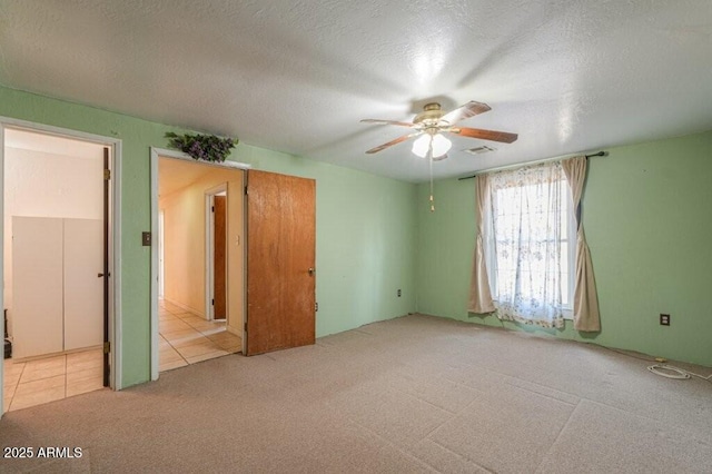1055 S 4th St, Coolidge, AZ 85128 - unfurnished bedroom featuring tile patterned flooring, visible vents, a ceiling fan, carpet floors, and a textured ceiling
