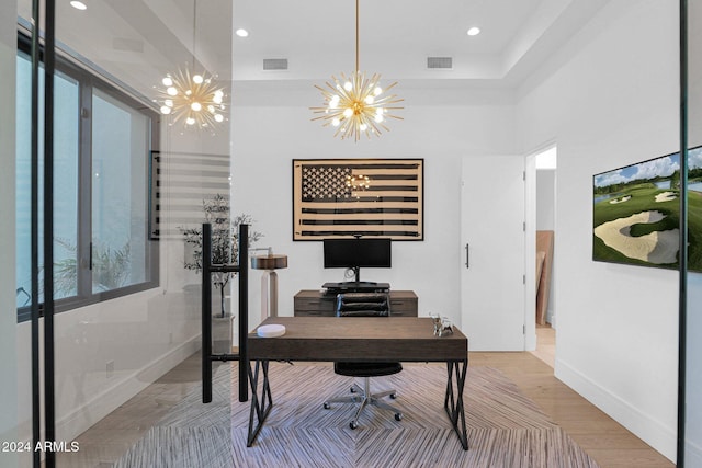 home office featuring hardwood / wood-style floors and an inviting chandelier