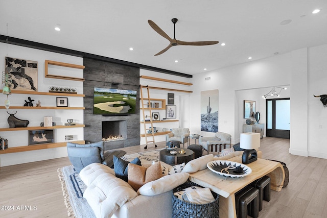 living room with a tile fireplace, light hardwood / wood-style flooring, and ceiling fan