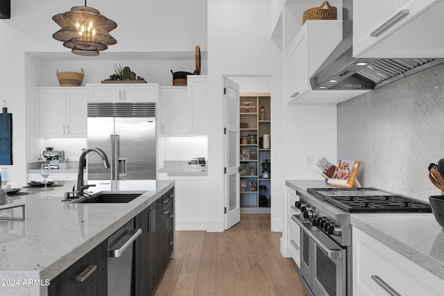 kitchen featuring white cabinets, hanging light fixtures, and high end appliances