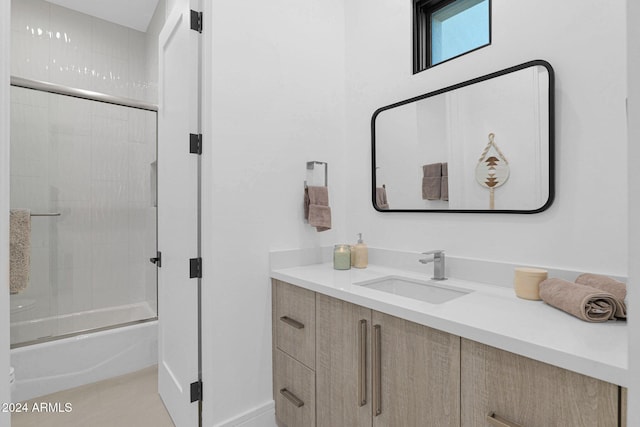 bathroom featuring vanity and bath / shower combo with glass door