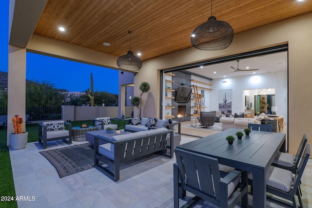 view of patio with an outdoor living space with a fireplace and ceiling fan