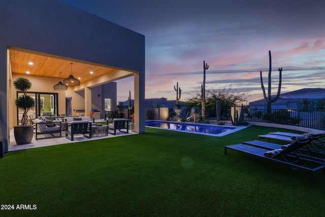 yard at dusk featuring outdoor lounge area, ceiling fan, a patio area, and a fenced in pool