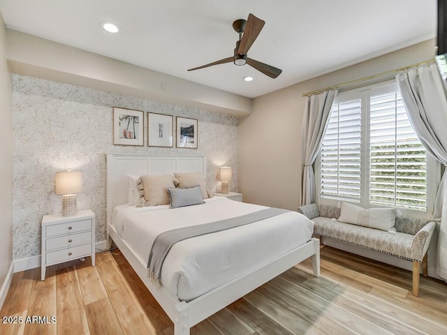 bedroom featuring multiple windows, hardwood / wood-style flooring, and ceiling fan