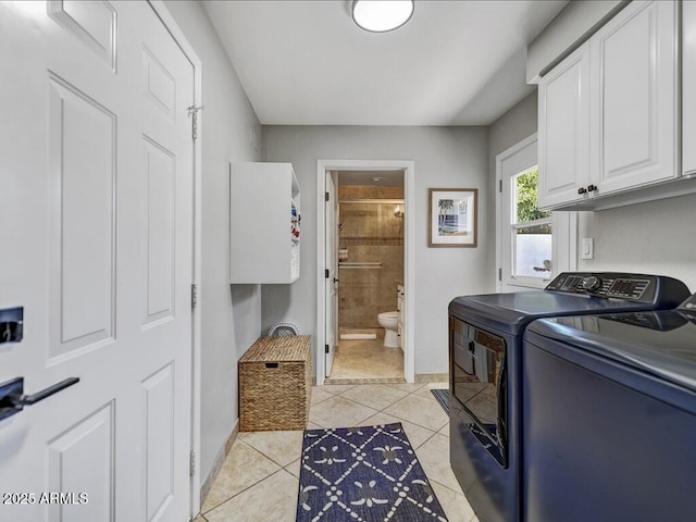 laundry area featuring cabinets, light tile patterned flooring, and independent washer and dryer