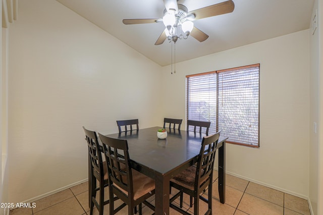 dining space with vaulted ceiling, ceiling fan, and light tile patterned floors