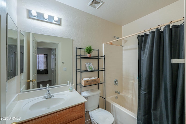 full bathroom with toilet, shower / tub combo, vanity, and a textured ceiling