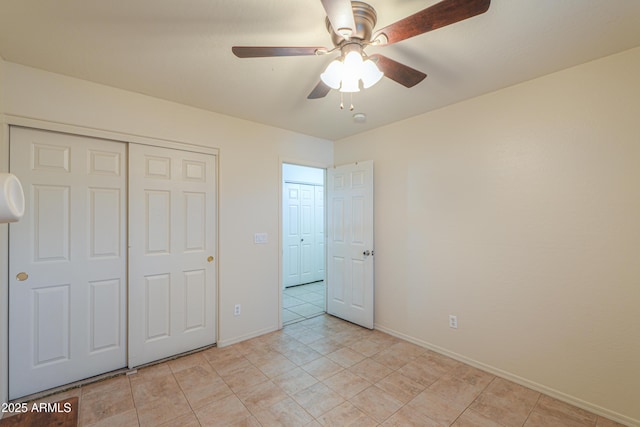 unfurnished bedroom with ceiling fan and a closet