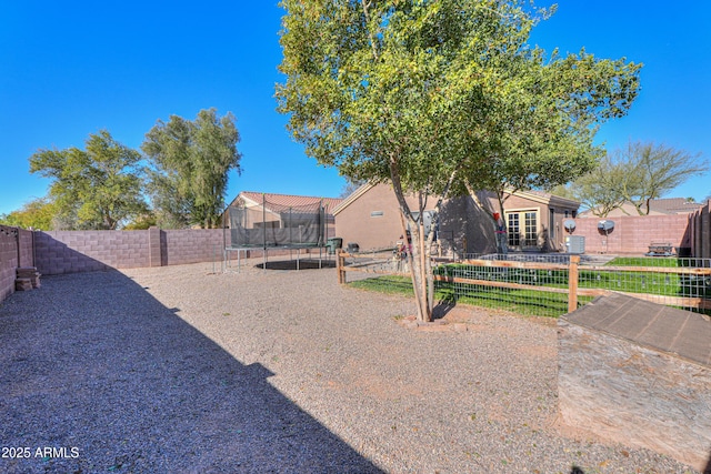 view of yard featuring a trampoline and a patio area