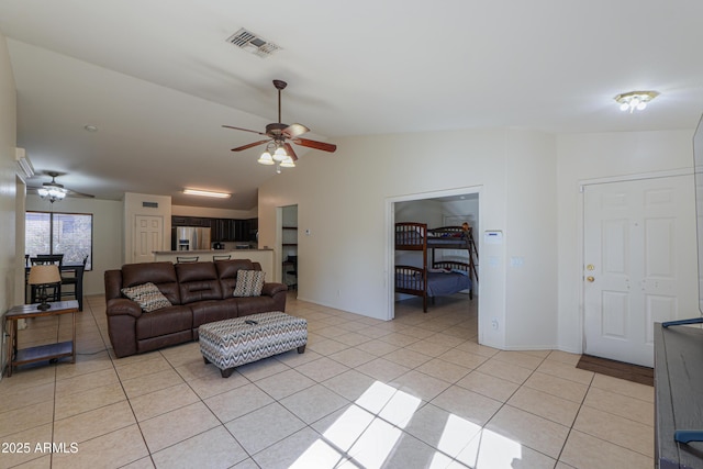 tiled living room with ceiling fan and lofted ceiling