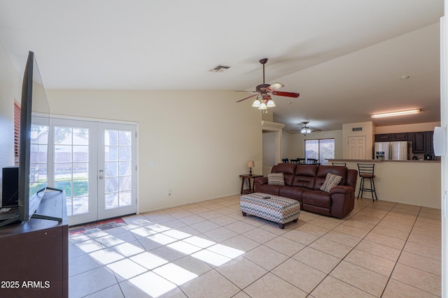 living room with vaulted ceiling, ceiling fan, light tile patterned floors, and french doors