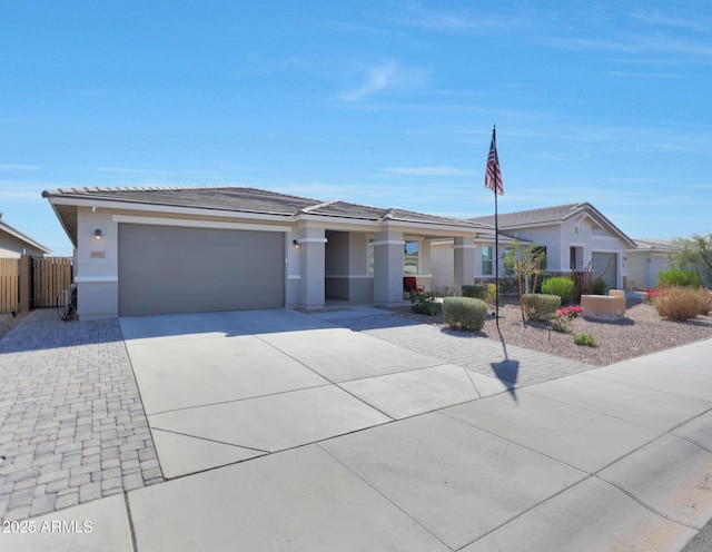 ranch-style house featuring an attached garage, fence, concrete driveway, and stucco siding