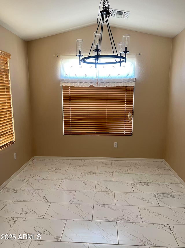 8507 W Pioneer St, Tolleson, AZ 85353 - spare room featuring marble look tiles, a chandelier, and lofted ceiling