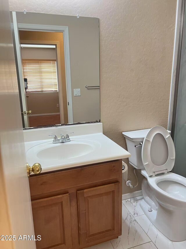 8507 W Pioneer St, Tolleson, AZ 85353 - bathroom with marble finish floors, vanity, and a textured wall