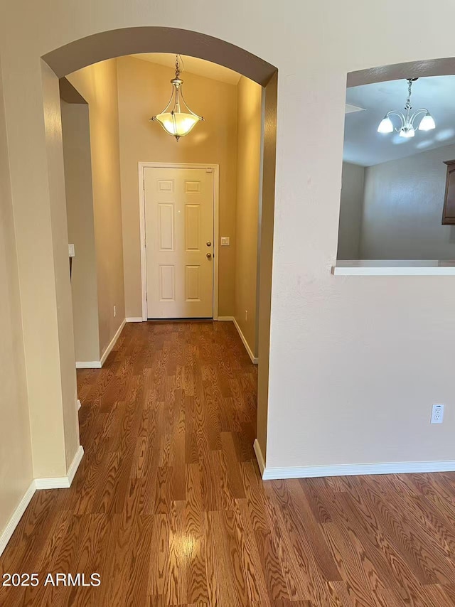 8507 W Pioneer St, Tolleson, AZ 85353 - hallway with arched walkways, wood finished floors, and a chandelier