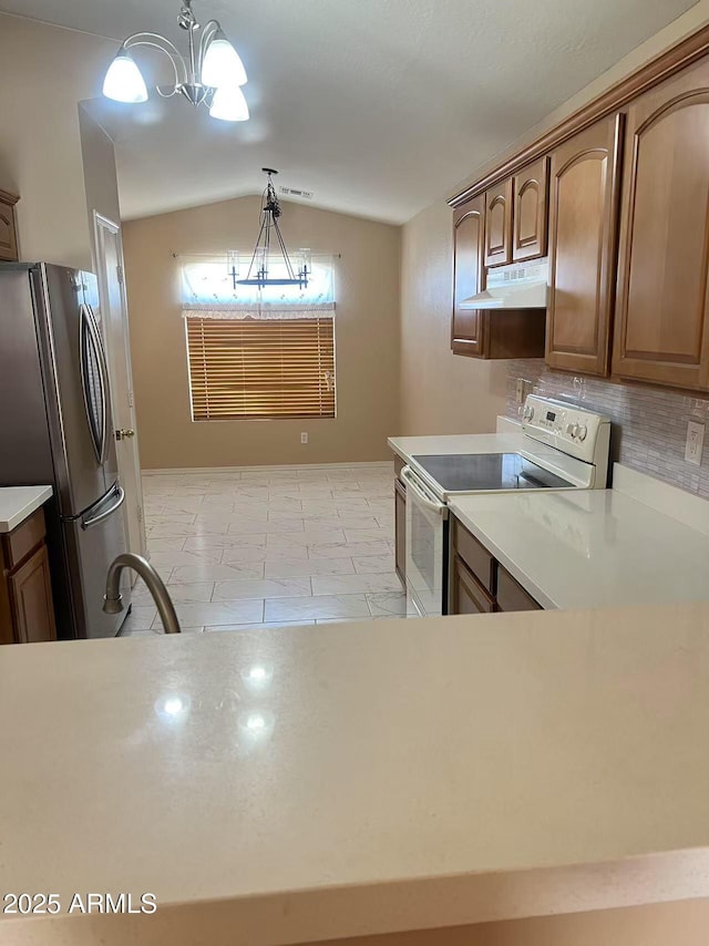 8507 W Pioneer St, Tolleson, AZ 85353 - kitchen with white range with electric cooktop, freestanding refrigerator, lofted ceiling, a chandelier, and under cabinet range hood