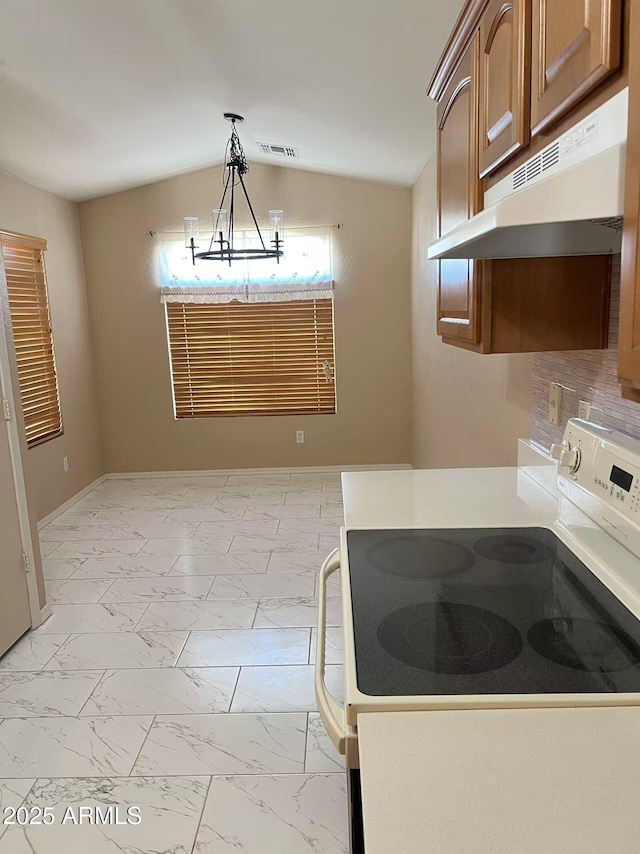 8507 W Pioneer St, Tolleson, AZ 85353 - kitchen with white electric range, under cabinet range hood, light marble finish flooring, hanging light fixtures, and vaulted ceiling