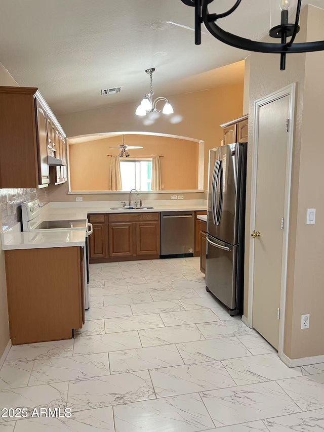 8507 W Pioneer St, Tolleson, AZ 85353 - kitchen featuring appliances with stainless steel finishes, light marble finish flooring, under cabinet range hood, and a chandelier