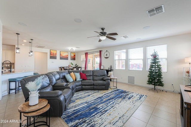 tiled living room with ceiling fan and sink