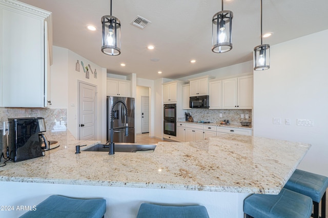 kitchen with a breakfast bar area, kitchen peninsula, pendant lighting, and black appliances