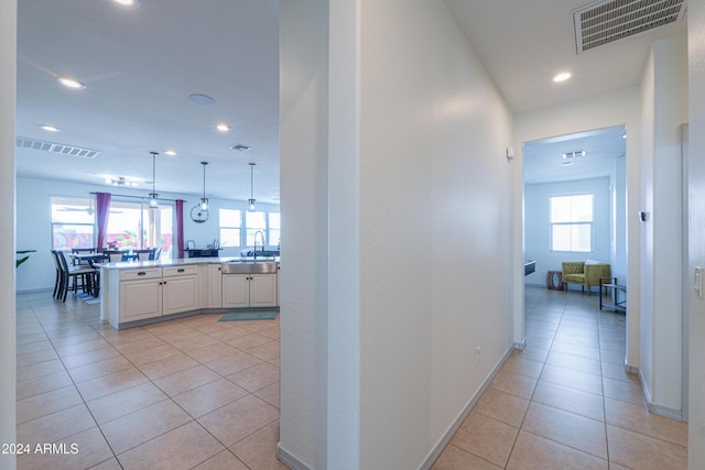 corridor featuring sink and light tile patterned floors