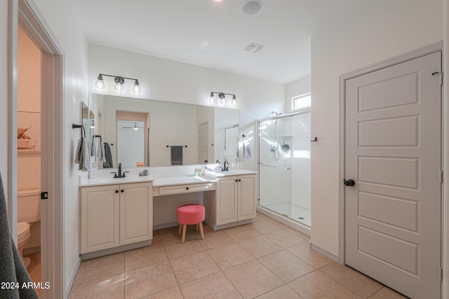 bathroom featuring tile patterned floors, a shower with door, vanity, and toilet