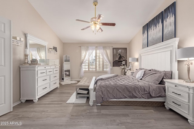 bedroom featuring lofted ceiling, light wood-type flooring, and a ceiling fan