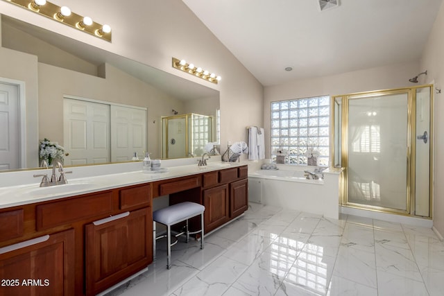 bathroom with vaulted ceiling, marble finish floor, a sink, and a bath