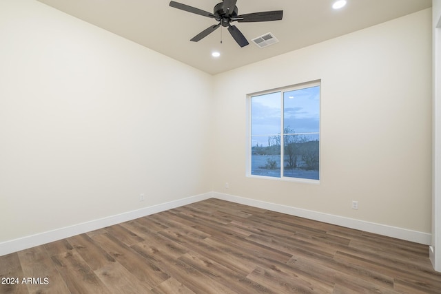 empty room with dark wood-type flooring and ceiling fan