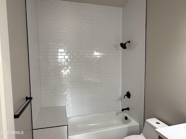 full bathroom with tiled shower / bath, vanity, and toilet