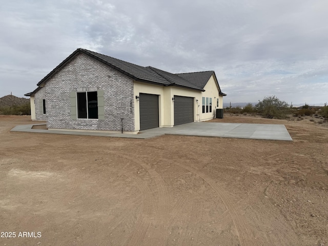 view of home's exterior with a garage and central air condition unit