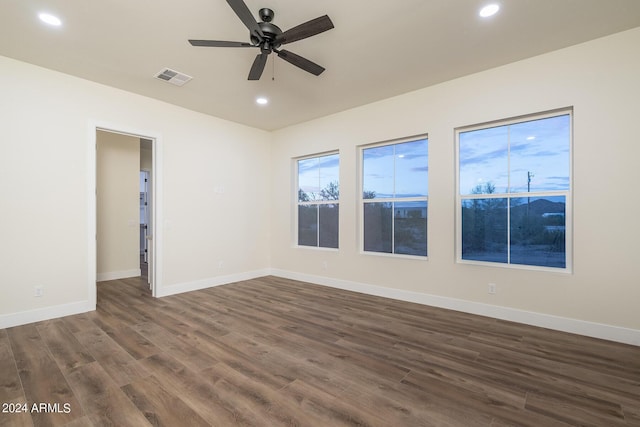 unfurnished room featuring dark wood-type flooring and ceiling fan