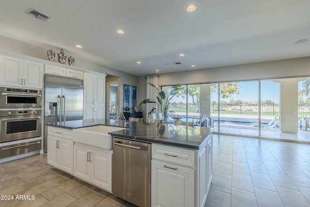 kitchen with appliances with stainless steel finishes, white cabinetry, and sink