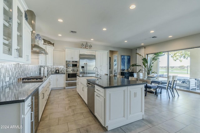 kitchen with sink, tasteful backsplash, a large island, white cabinetry, and stainless steel appliances