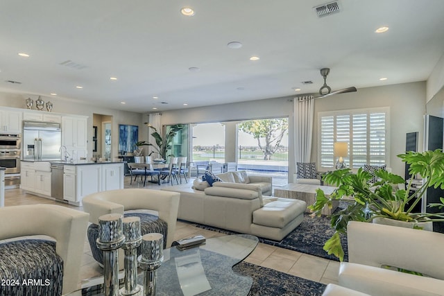 living room featuring light tile patterned floors, sink, and a wealth of natural light